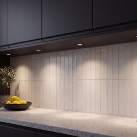 HiluX D1 Gen3 black recessed spotlights under dark kitchen cabinets, lighting a white tiled backsplash and terrazzo worktop